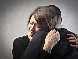 Woman crying and being comforted due to grief